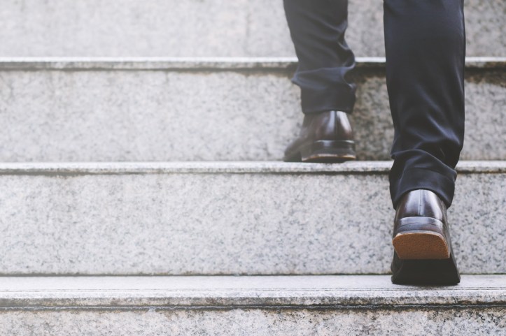 businessman legs walking the stairs in modern city.