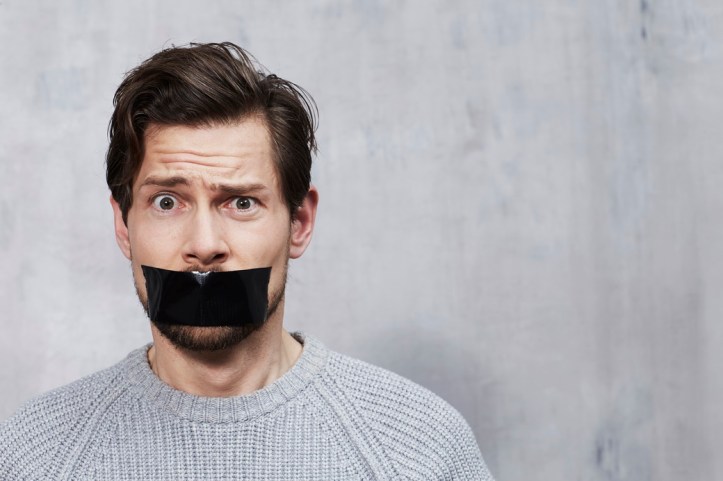 Confused man with tape over mouth, portrait